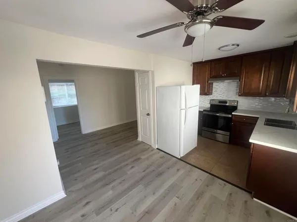 a kitchen with stainless steel appliances a refrigerator a sink dishwasher a stove top oven a refrigerator and cabinets