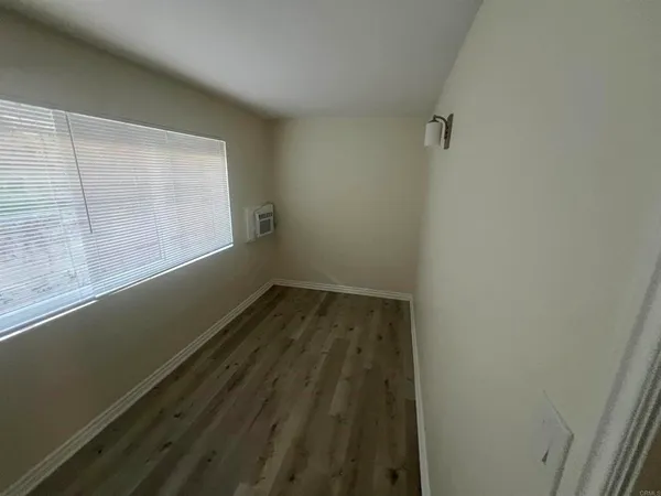 a view of a room with wooden floor and window