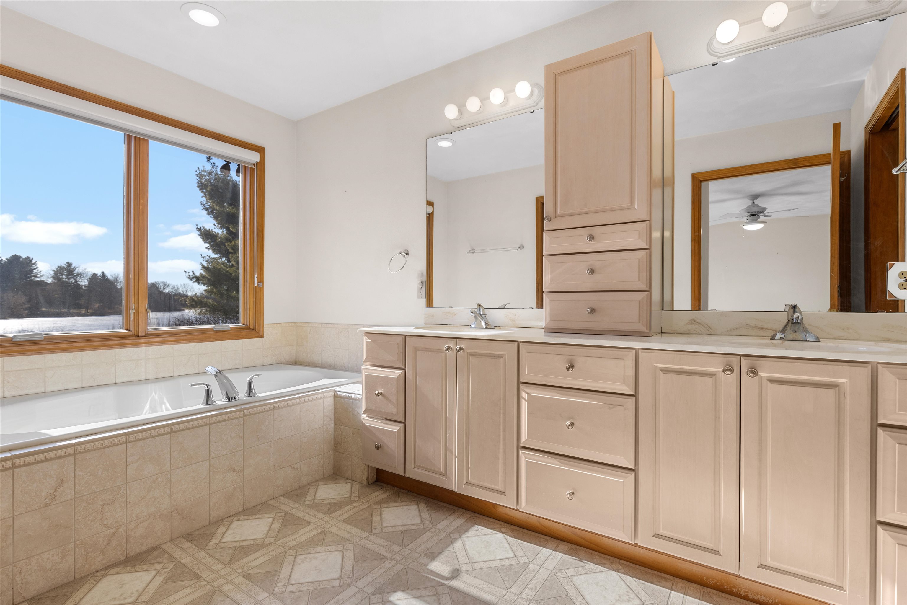 8317 Snaresbrook Road Roscoe, IL 61073 - Photo 15 of 45 a spacious bathroom with a granite countertop sink mirror and a bathtub