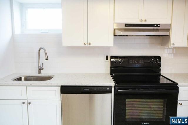 134 Berkshire Road Hasbrouck Heights, NJ 07604 - Photo 14 of 17 a kitchen with a stove and a white cabinet