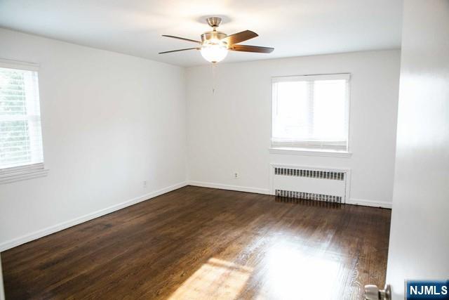 134 Berkshire Road Hasbrouck Heights, NJ 07604 - Photo 7 of 17 an empty room with wooden floor fan and windows