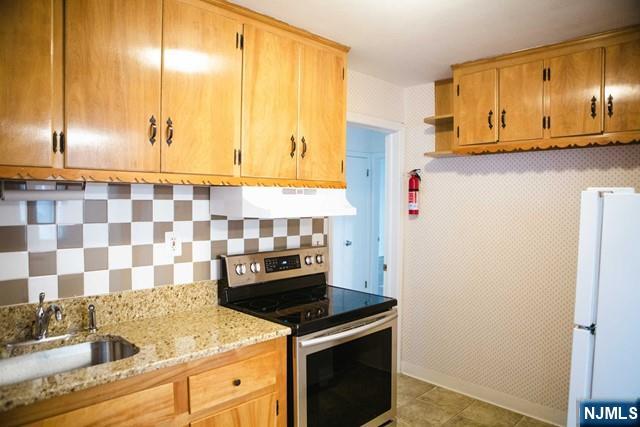 134 Berkshire Road Hasbrouck Heights, NJ 07604 - Photo 8 of 17 a kitchen with stainless steel appliances granite countertop a sink stove and refrigerator