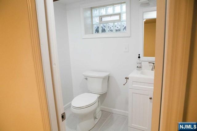 134 Berkshire Road Hasbrouck Heights, NJ 07604 - Photo 9 of 17 a white toilet sitting next to a bathroom sink and vanity