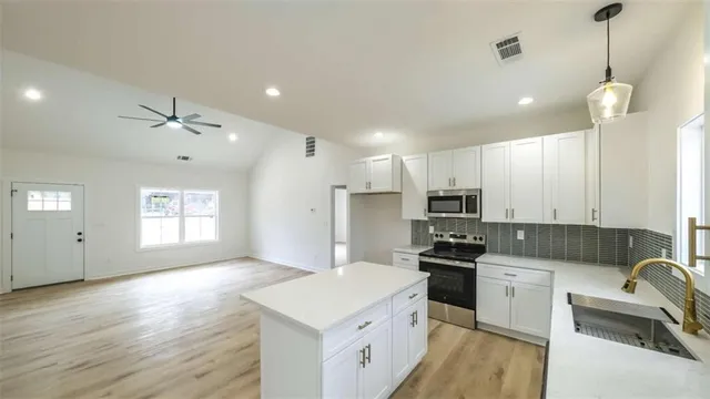 a kitchen with white cabinets and stainless steel appliances