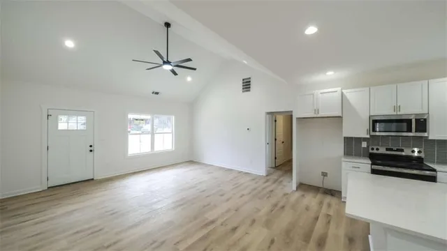 a view of kitchen with sink refrigerator and window
