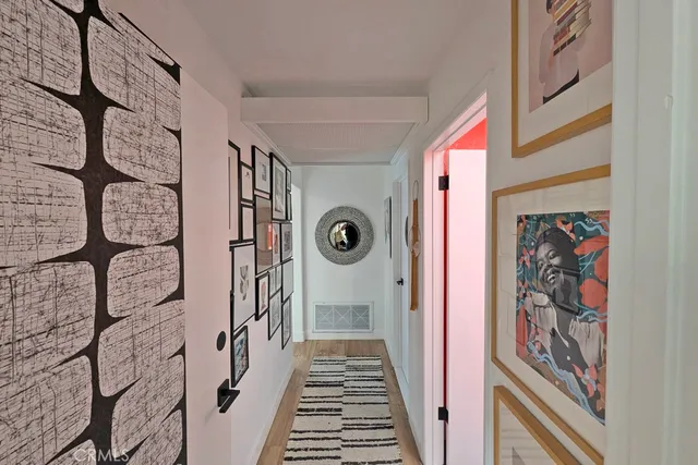 a living room with furniture a clock tv and kitchen view