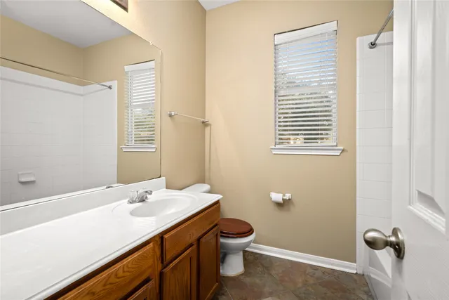 a bathroom with a sink a toilet and shower