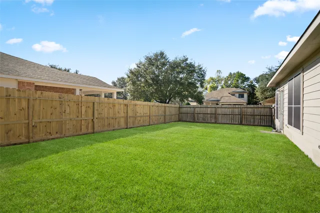 a view of a backyard with wooden fence