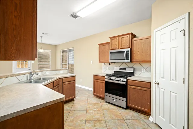 a kitchen with stainless steel appliances granite countertop a stove top oven a sink and dishwasher