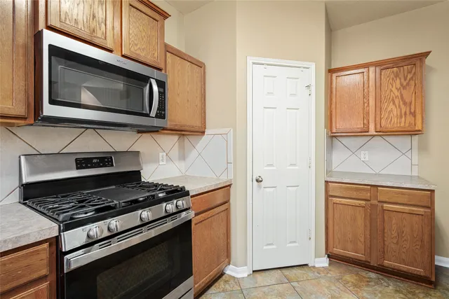 a kitchen with stainless steel appliances granite countertop white cabinets and a stove top oven