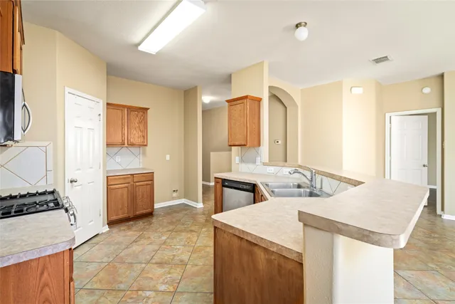 a kitchen with a stove a sink and a refrigerator