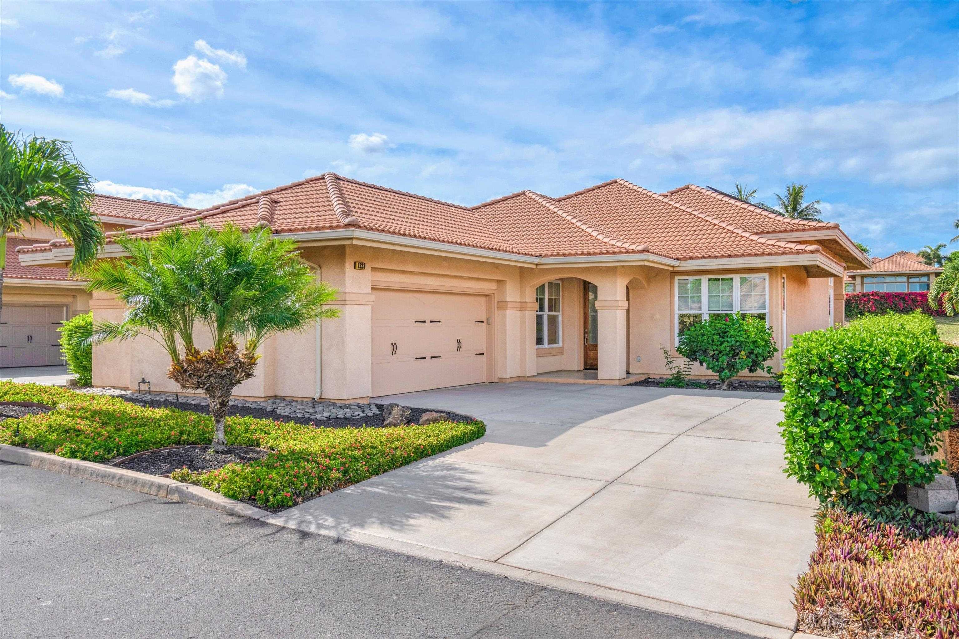 1323 Umeke Circle, Unit 102 Kihei, HI 96753 - Photo 2 of 50 a front view of a house with a yard and garage