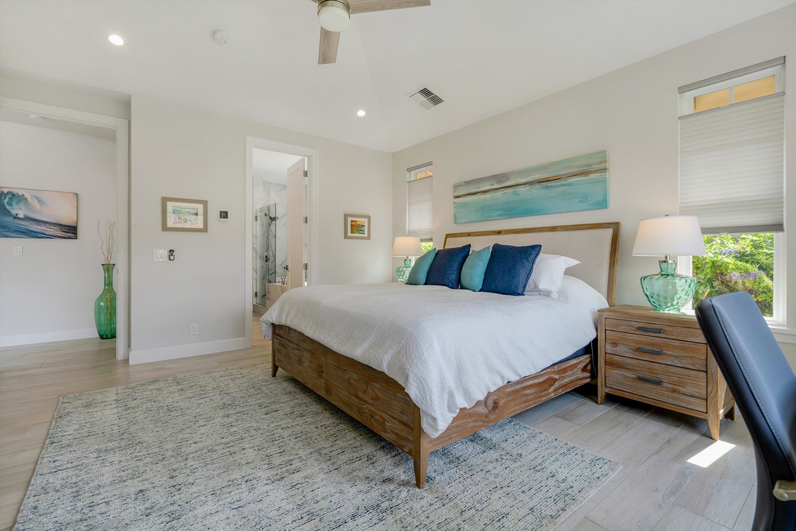 1323 Umeke Circle, Unit 102 Kihei, HI 96753 - Photo 24 of 50 a bedroom with a bed and a chandelier