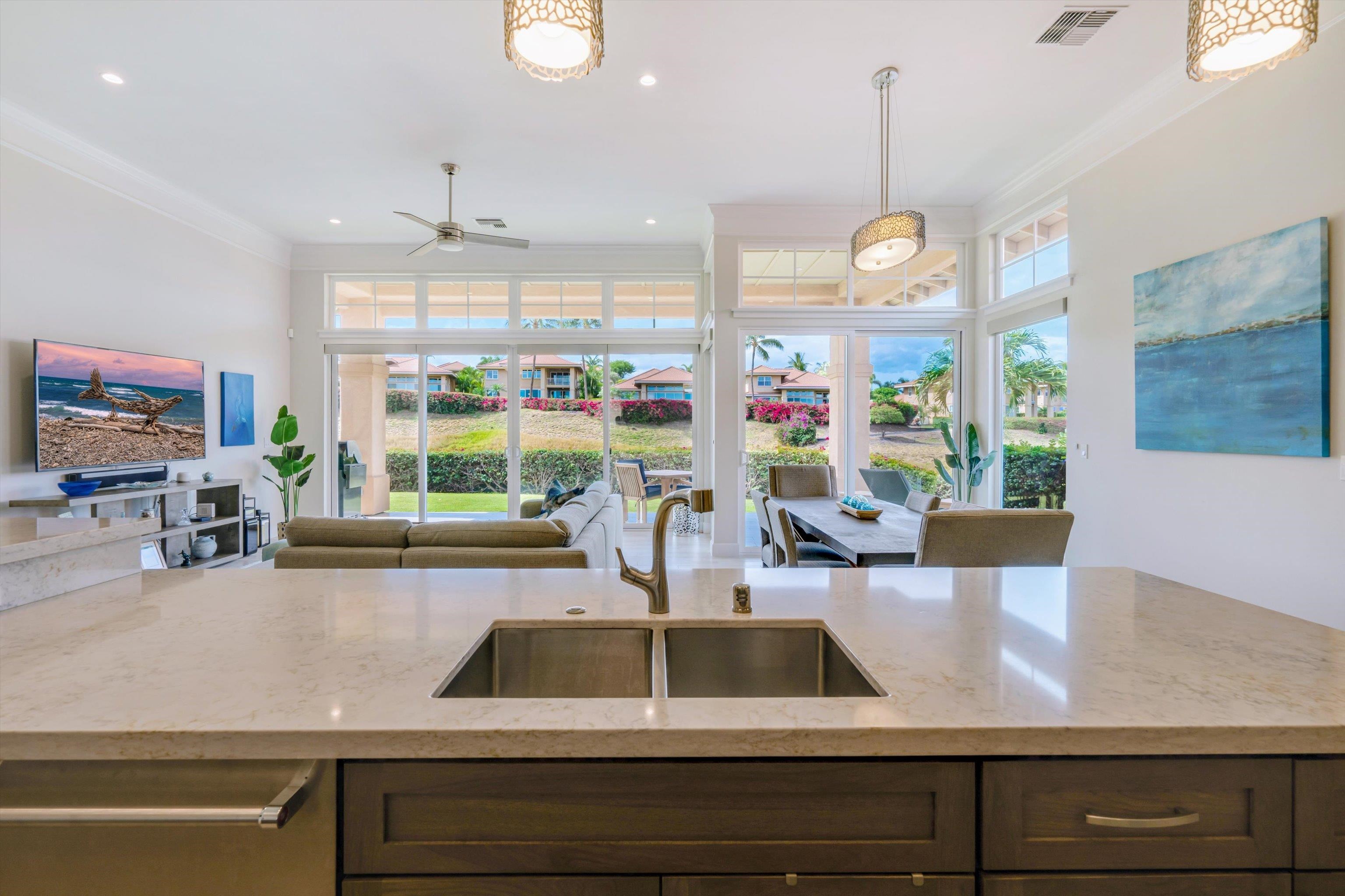 1323 Umeke Circle, Unit 102 Kihei, HI 96753 - Photo 27 of 50 a view of a kitchen with kitchen island a large window cabinets a sink and a counter space