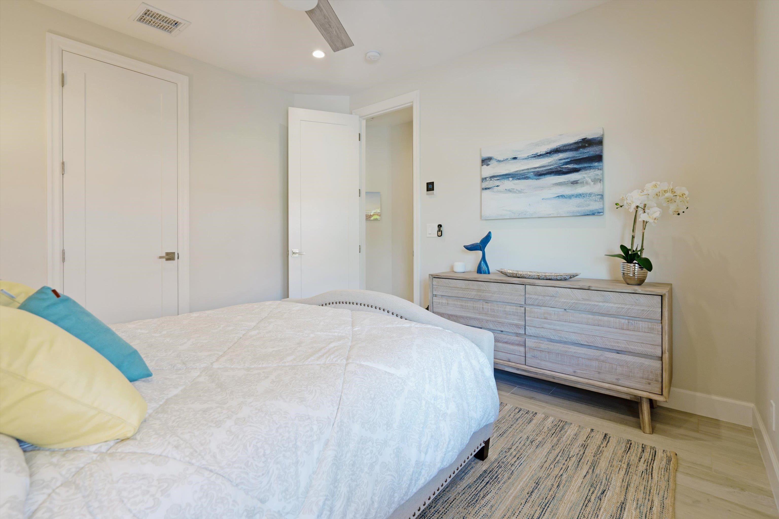 1323 Umeke Circle, Unit 102 Kihei, HI 96753 - Photo 28 of 50 a bedroom with a bed and cabinets