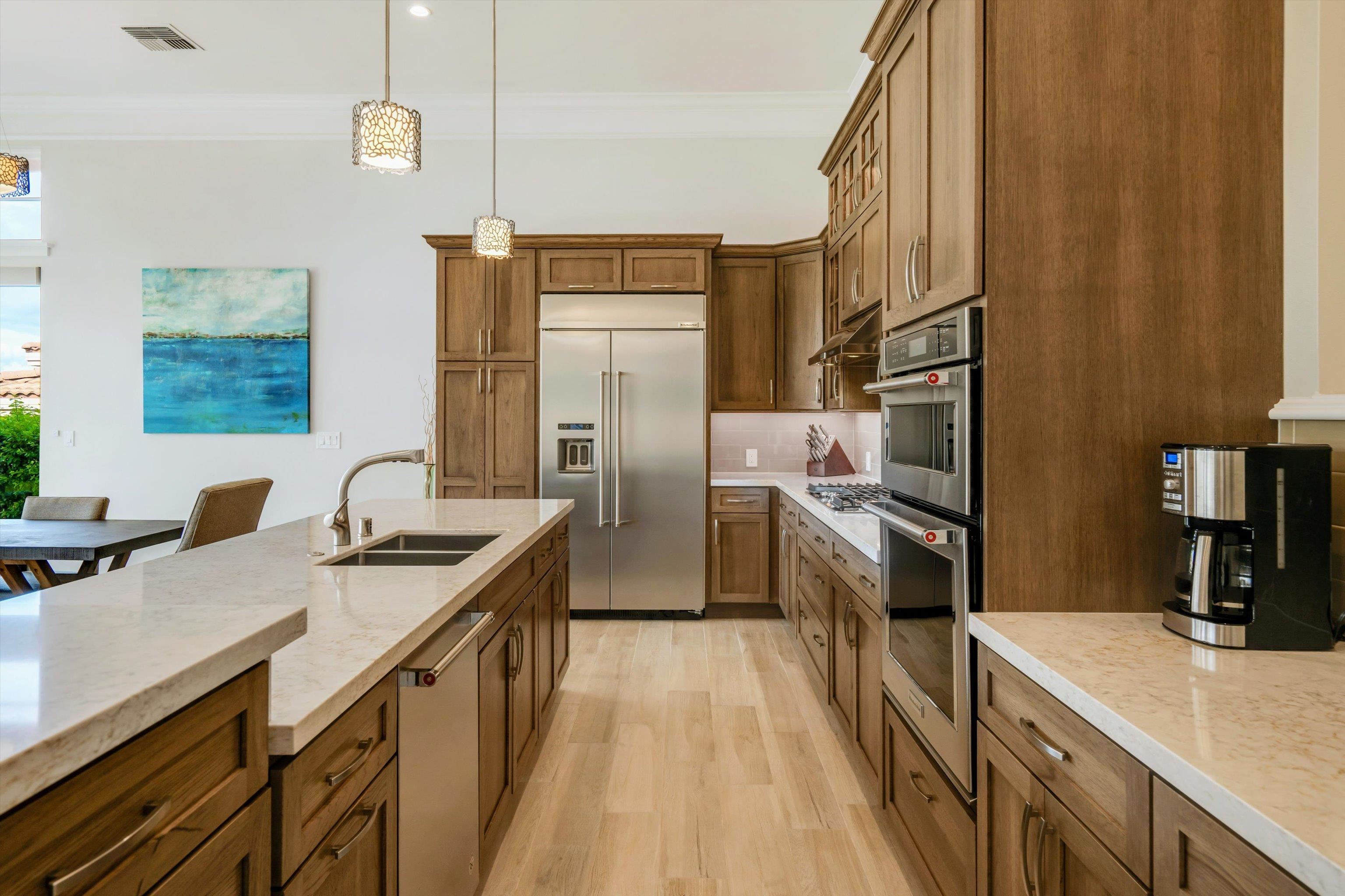 1323 Umeke Circle, Unit 102 Kihei, HI 96753 - Photo 29 of 50 a kitchen with stainless steel appliances granite countertop a sink a stove and a refrigerator