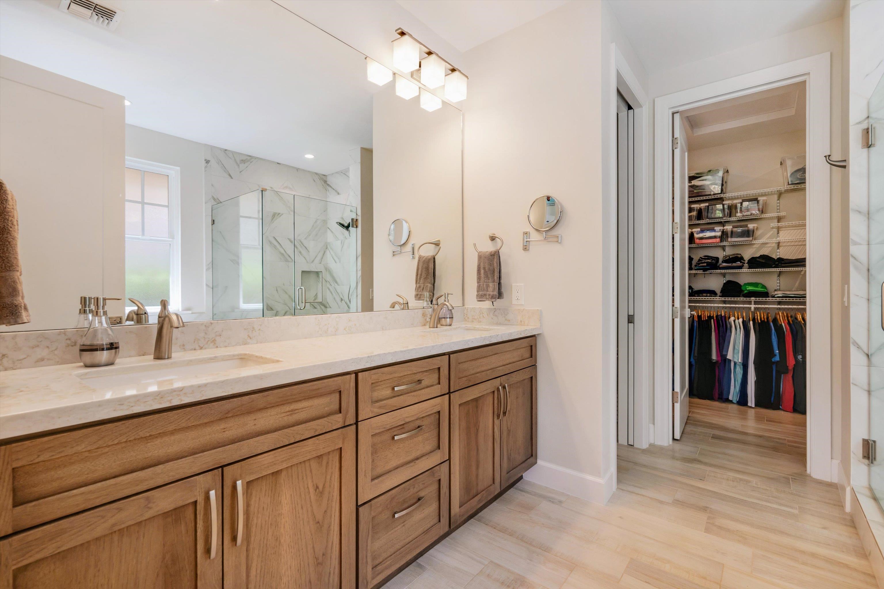 1323 Umeke Circle, Unit 102 Kihei, HI 96753 - Photo 35 of 50 a spacious bathroom with a granite countertop sink a mirror a vanity and shower