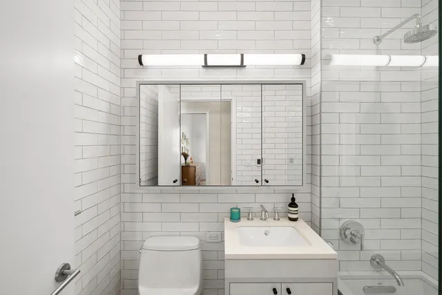 a bathroom with a sink a toilet and mirror