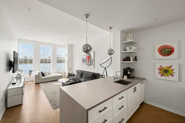 a kitchen with white cabinets and window