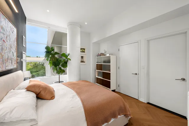 a bedroom with a bed and a potted plant