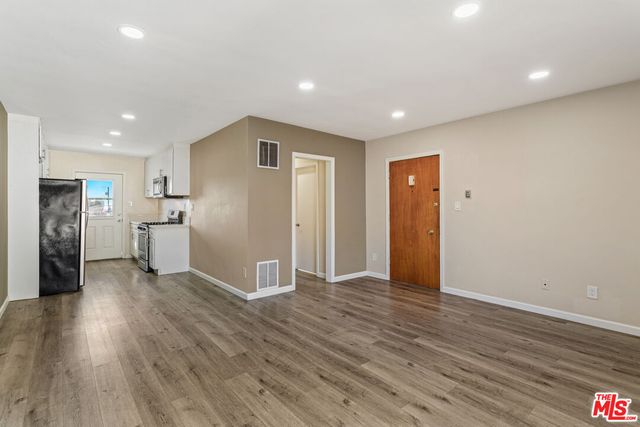 a view of empty room with wooden floor