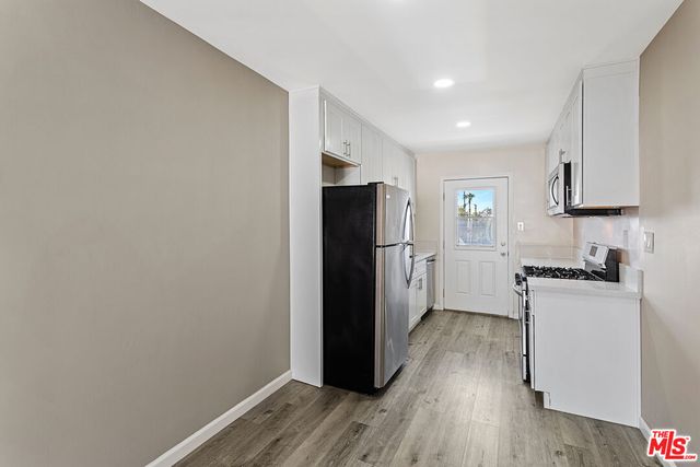 a kitchen with a refrigerator and a stove top oven