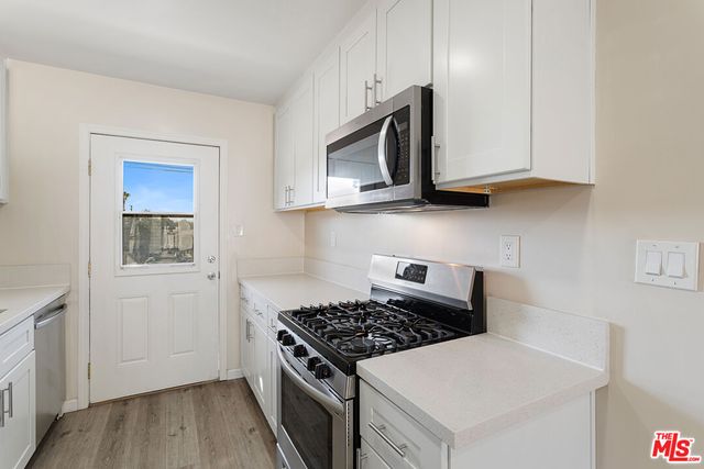a kitchen with stainless steel appliances a stove a microwave and cabinets
