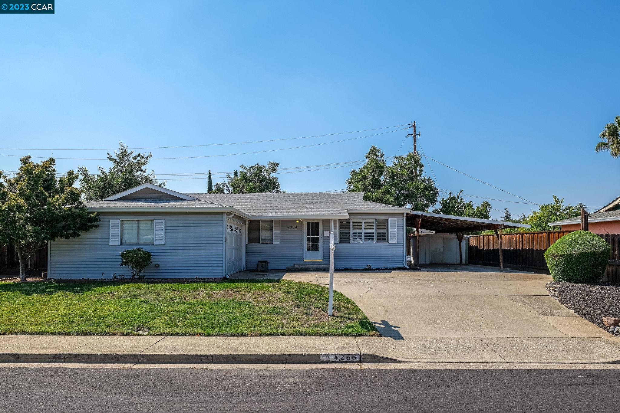 a front view of a house with a garden and plants