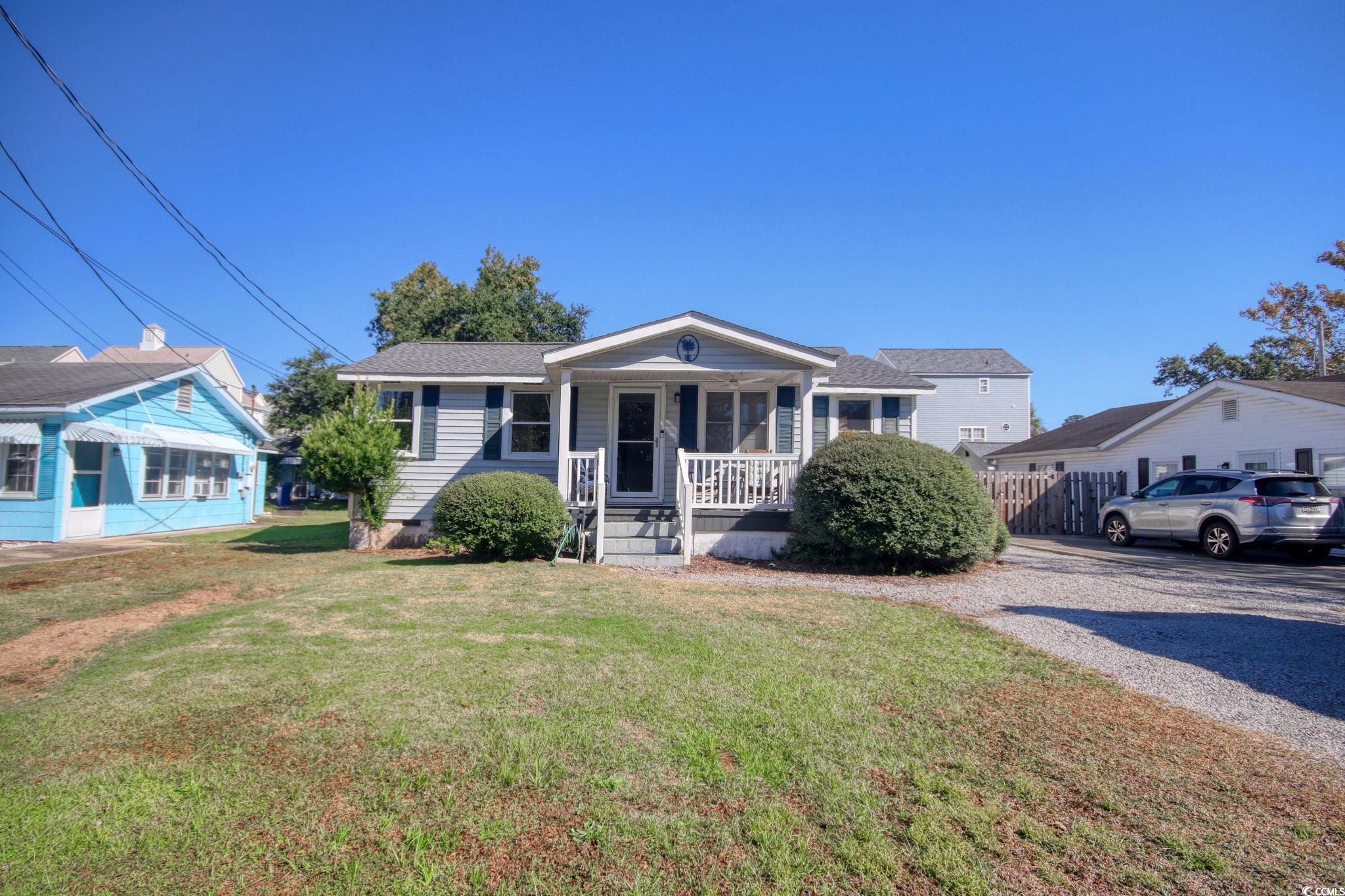 Bungalow featuring covered porch and a front yard