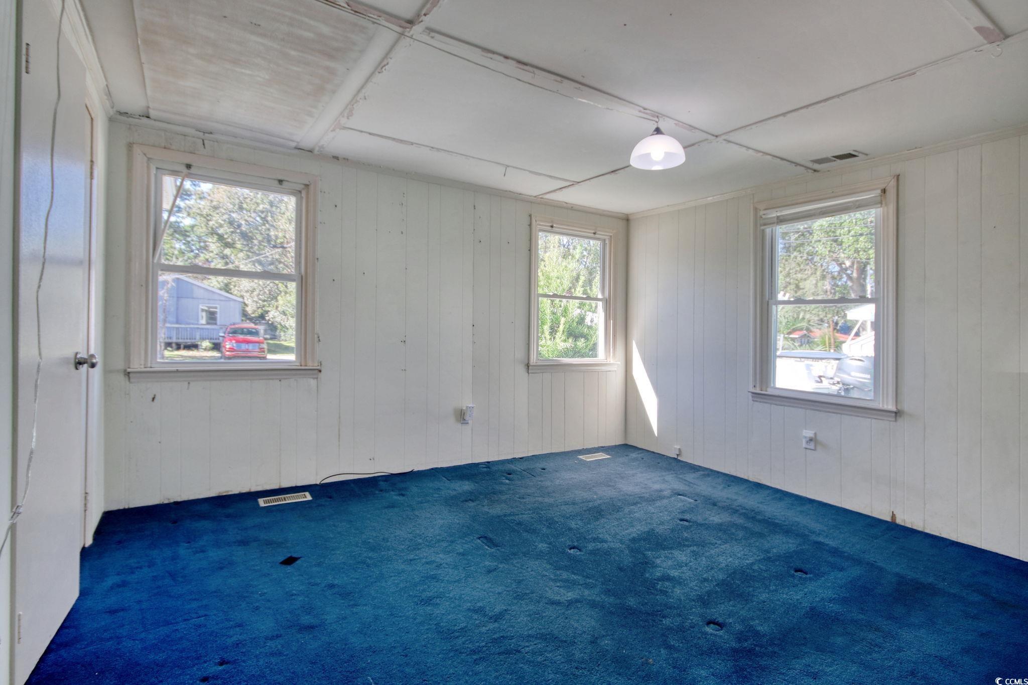 714 3rd Avenue South Surfside Beach, SC 29575 - Photo 14 of 30 Unfurnished room featuring carpet floors and wood walls
