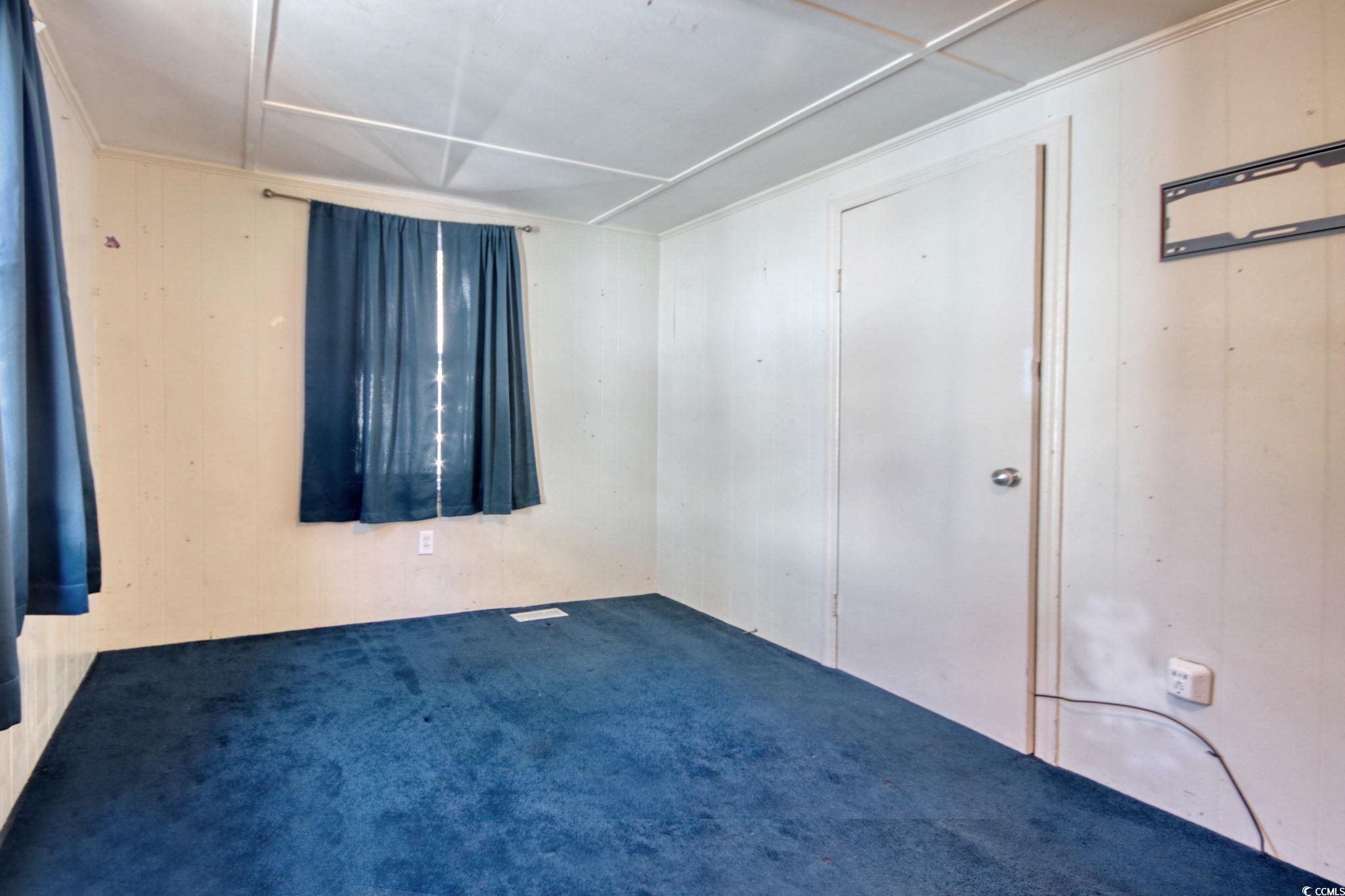 714 3rd Avenue South Surfside Beach, SC 29575 - Photo 17 of 30 Unfurnished bedroom featuring wooden walls and carpet