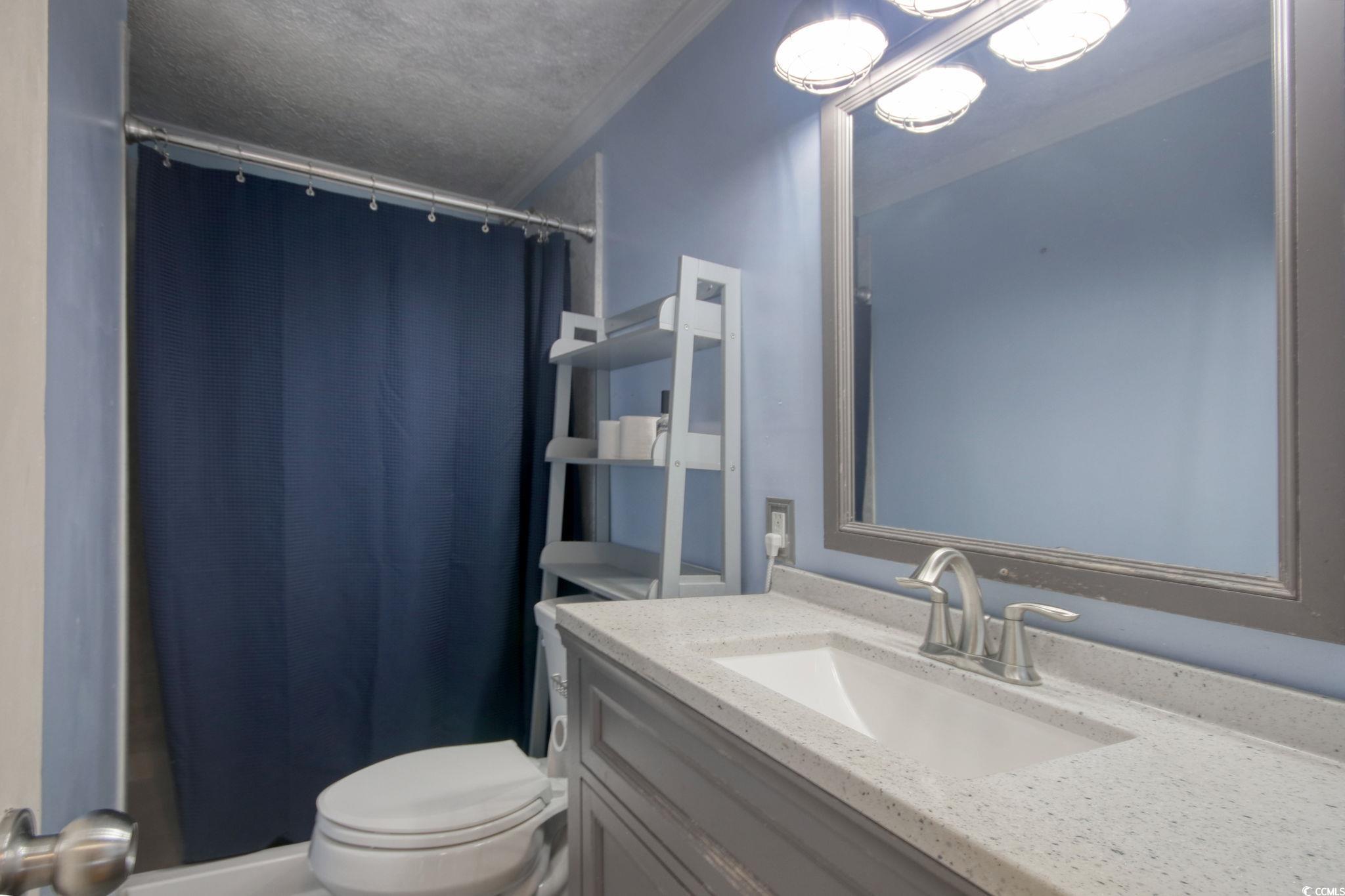 714 3rd Avenue South Surfside Beach, SC 29575 - Photo 19 of 30 Bathroom featuring a shower stall, vanity, and a textured ceiling