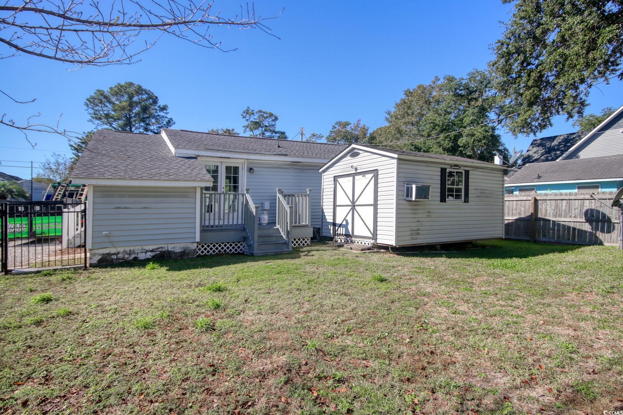 714 3rd Avenue South Surfside Beach, SC 29575 - Photo 23 of 30 Back of property with a fenced backyard, a shingled roof, and a storage unit