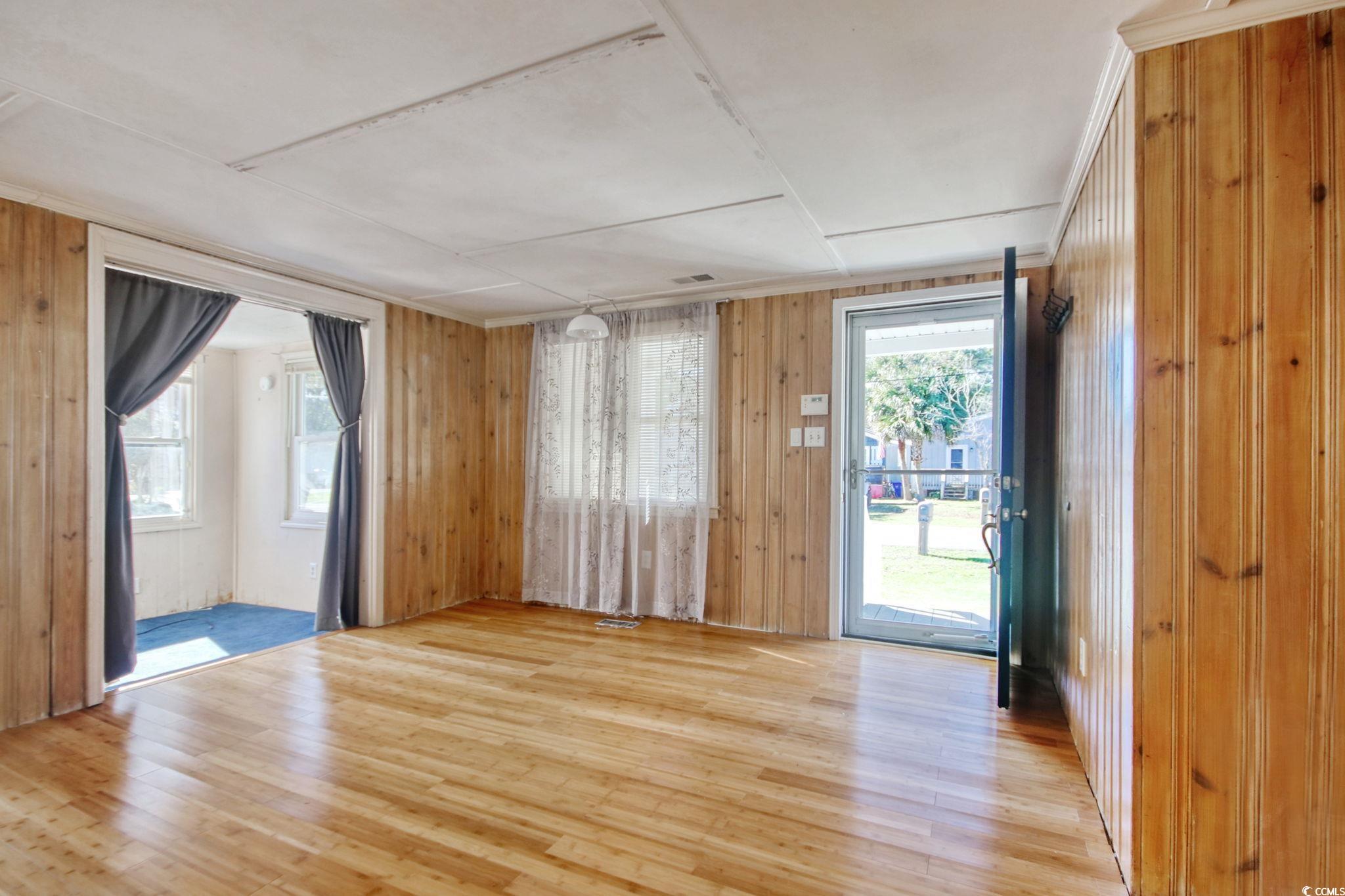 714 3rd Avenue South Surfside Beach, SC 29575 - Photo 4 of 30 Empty room with wood walls and hardwood / wood-style floors