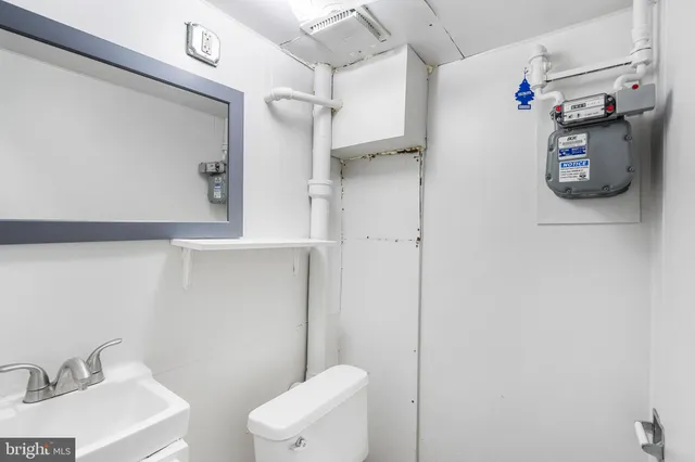 a bathroom with a sink a toilet and shower curtain