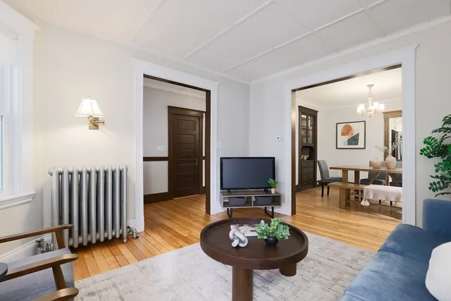a living room with furniture a flat screen tv and a table