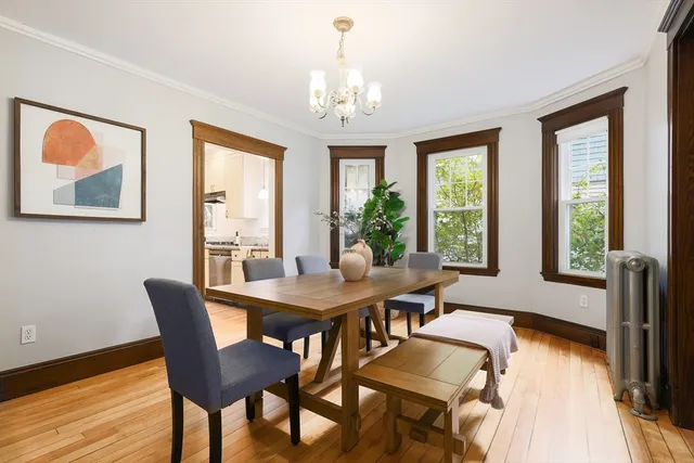 a dining room with furniture a chandelier and wooden floor
