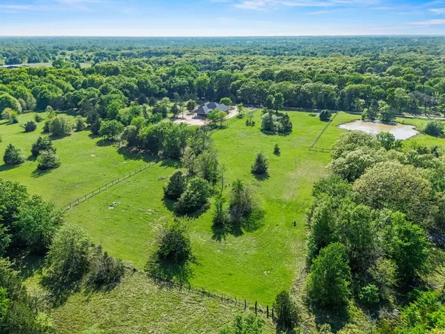 an aerial view of residential houses with outdoor space and trees