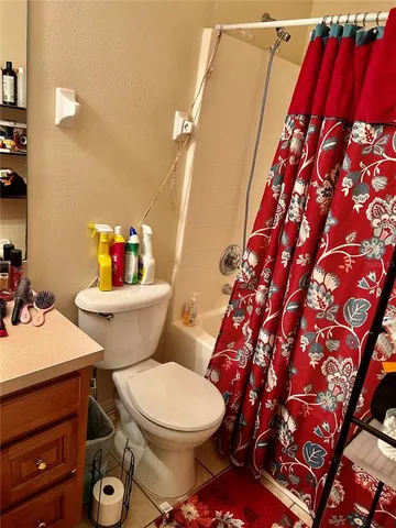 a white toilet sitting next to a shower curtain