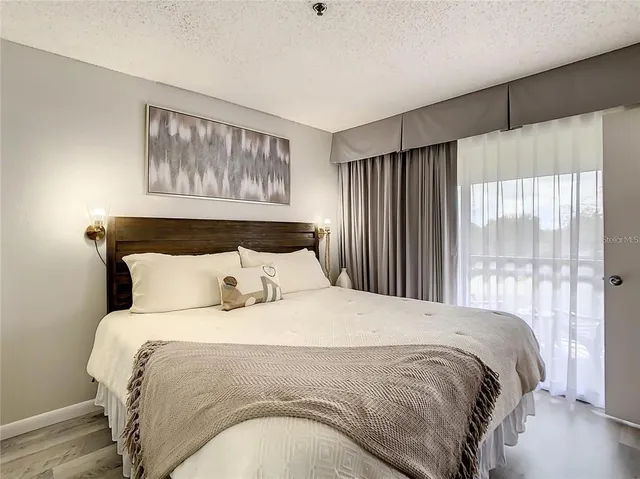 a large bed sitting in a bedroom next to a window