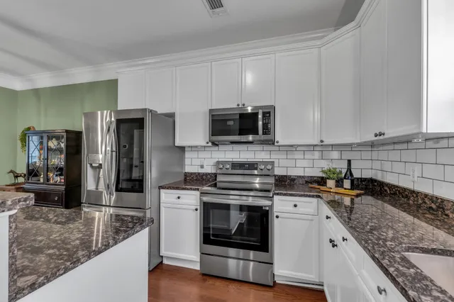 a kitchen with stainless steel appliances granite countertop a stove a sink and a microwave