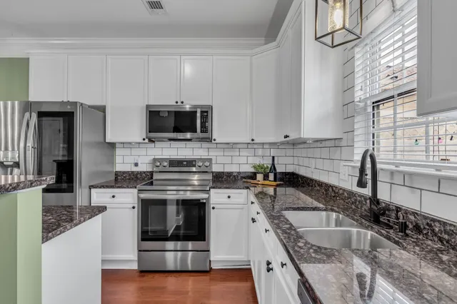 a kitchen with stainless steel appliances granite countertop a stove sink microwave and cabinets