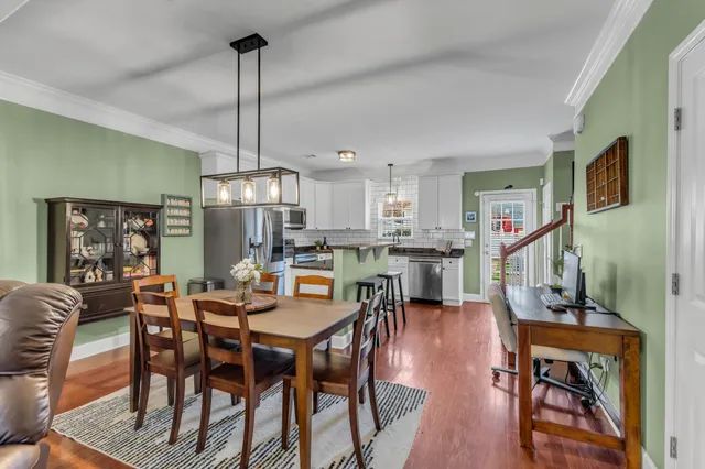 a kitchen with stainless steel appliances granite countertop a refrigerator a stove top oven a sink dishwasher and white cabinets with wooden floor