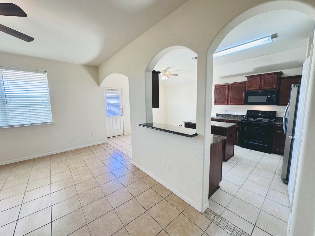 19309 W.T. Gallaway Street Manor, TX 78653 - Photo 15 of 38 a kitchen with stainless steel appliances granite countertop a refrigerator a stove and a sink