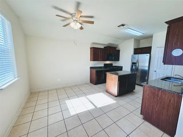 a kitchen with stainless steel appliances granite countertop a refrigerator and a sink