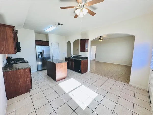 a kitchen with stainless steel appliances granite countertop a stove a sink and a refrigerator