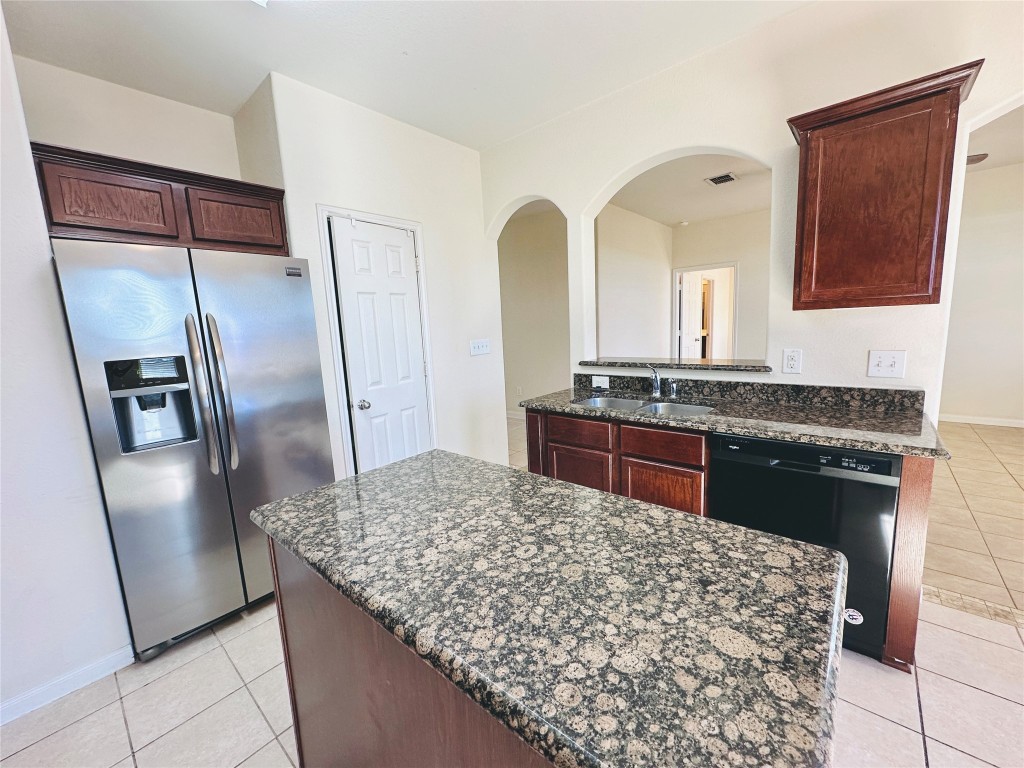 19309 W.T. Gallaway Street Manor, TX 78653 - Photo 22 of 38 a kitchen with stainless steel appliances granite countertop a refrigerator and a sink