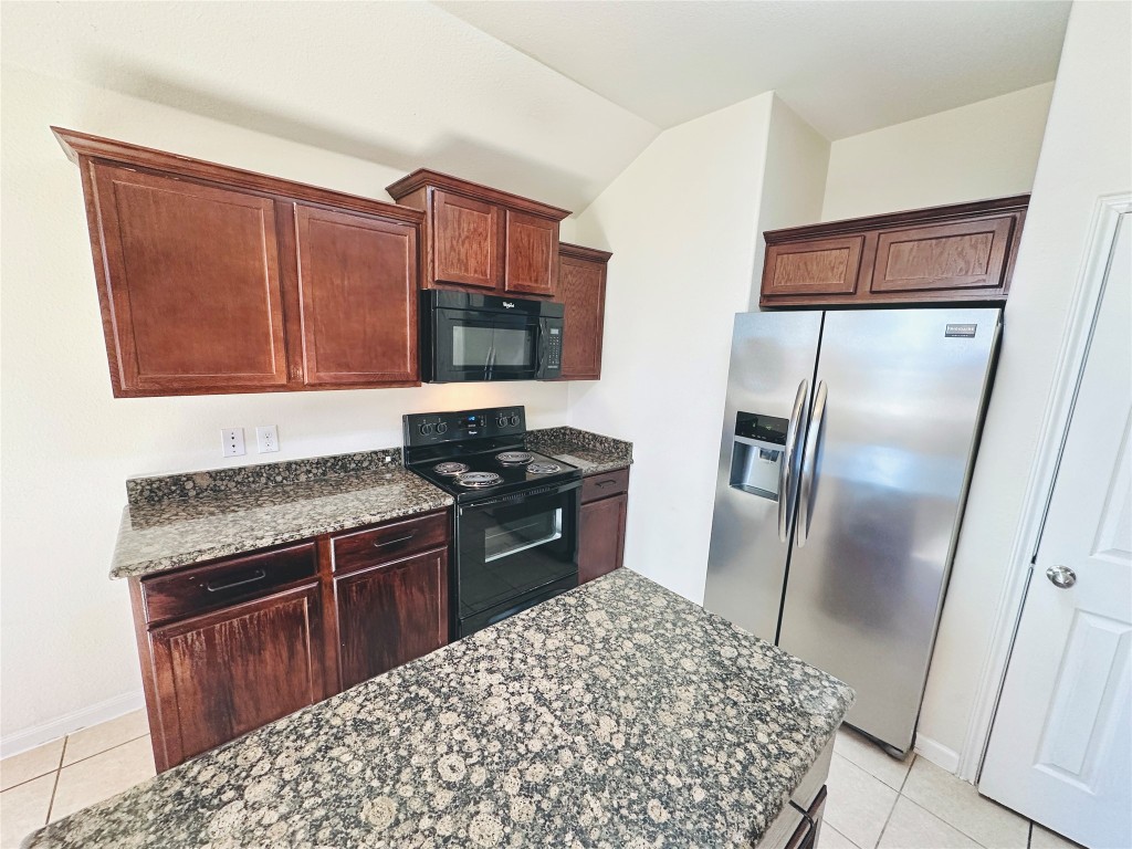 19309 W.T. Gallaway Street Manor, TX 78653 - Photo 23 of 38 a kitchen with stainless steel appliances granite countertop a refrigerator stove and sink