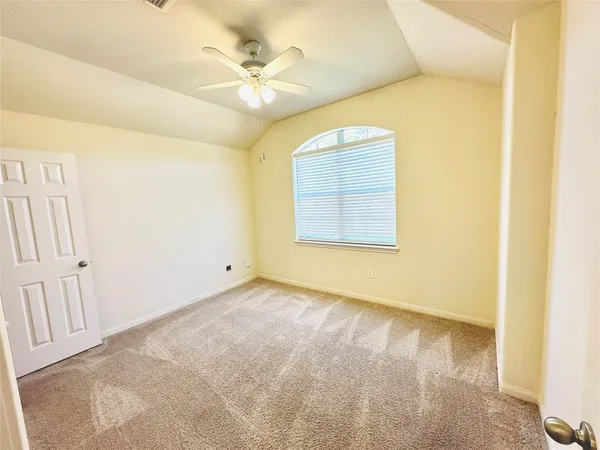 an empty room with a ceiling fan and a window