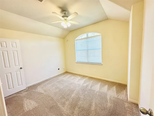 an empty room with a ceiling fan and a window